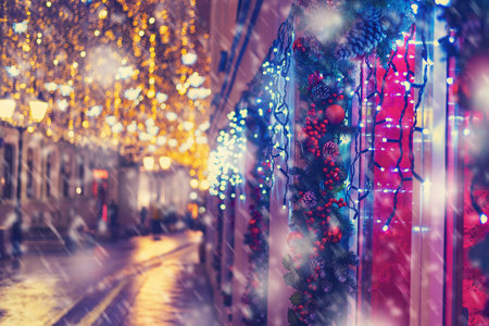 Windows of the house are snow decorated with balls and garlands during the celebration of the new year. City street with night lantern lightsの写真素材