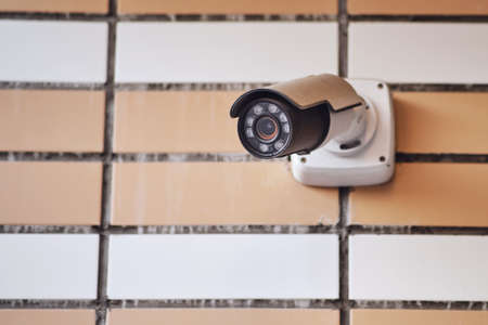 Outdoor surveillance security camera at the entrance of a residential building. CCTV camera on an apartment houseの写真素材