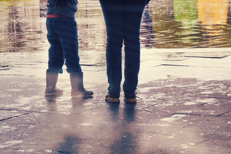 Legs of people standing in the rain in bad autumn weather