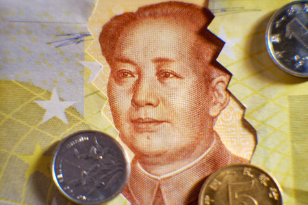 Chinese yuan money and torn euro, close-up. Euros bills and yuan from China