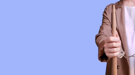 Arrested woman teacher handcuffed on a blue background, banner copy spaceの写真素材