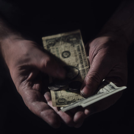 Man hands hold money US dollars on a black background, close-up. USA cash in the dirty hands of an...
