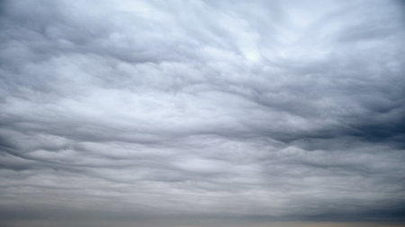 Dark storm clouds are drifting across a dramatic gray sky, time lapseの写真素材