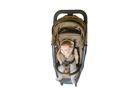 A happy child is sitting in a baby carriage on a studio, isolated on a white background. Smiling toddler baby boy in a transformer stroller for transporting children, age eight monthsの写真素材