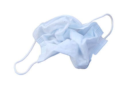 Infected medical masks is lying in the dirt on the ground, isolated on a white background