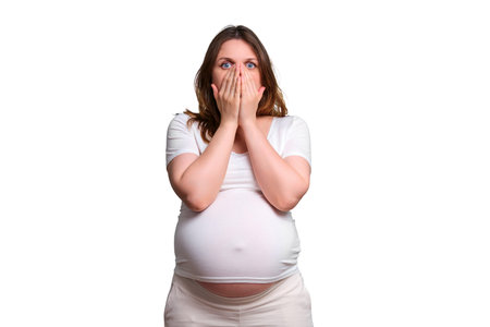 Emotion of shock in pregnant woman, studio shot on white backgroundの写真素材