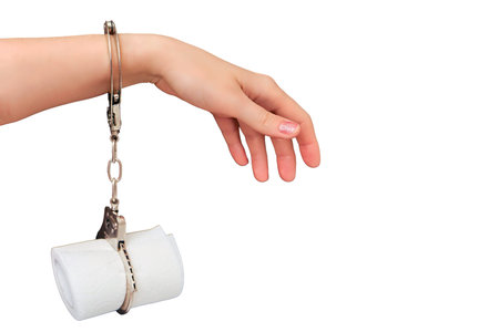 A woman's hand is handcuffed to toilet paper, a background of dark brown stone, isolated on a white...