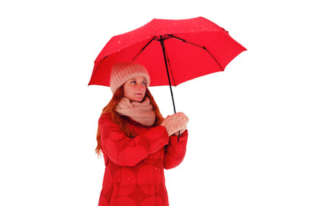 A woman with a red umbrella stands in a winter forest among trees in the snow, isolated on a white background. An adult happy woman with red hair takes shelter from the snow with an umbrellaの写真素材