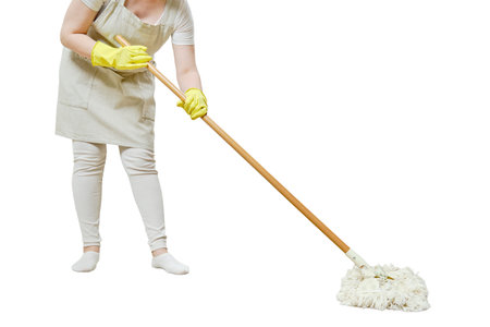 A woman in an apron cleans the floor with a mop in a home kitchen, isolated on a white backgroundの写真素材