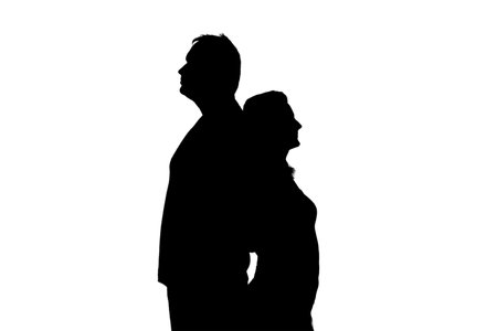 Silhouette of sad man and woman in a quarrel, isolated on a white background. Divorce of husband and wife in the evening light of the home living roomの写真素材