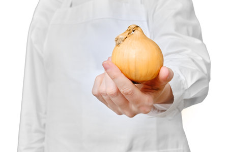 Man chef with onion in hand isolated on a white background, copy spaceの写真素材