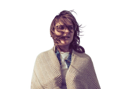 A woman with glasses, her hair fluttering in the wind, isolated on a white background