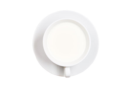 White cup with milk on a saucer, isolated on a white backgroundの写真素材