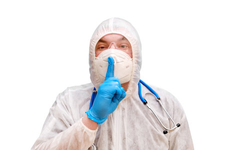 Man doctor medic in a protective suit uniform with goggles and face mask, isolated on a white background. Paramedic in white antiviral protective clothing wearing an N95 respirator and safety glassesの写真素材