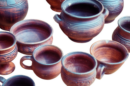 Pottery handmade in the old style, isolated on a white background. Top view of clay pots, vases, cups and jugs, isolated on a white background. Master's works in pottery workshop.の写真素材