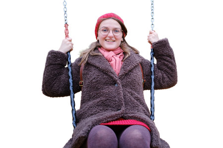 Woman swinging on a swing in autumn park, isolated on a white backgroundの写真素材