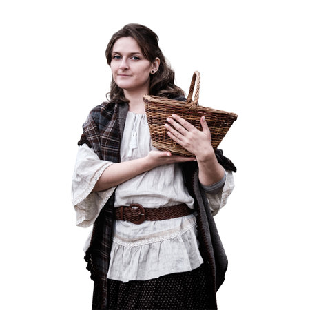 Happy young woman with wicker basket in hands, isolated on a white background. Woman in a retro dress on a background of an old houseの写真素材