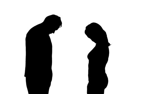 Silhouette of sad man and woman, isolated on a white background. Divorce of husband and wife in the evening light of the home living roomの写真素材