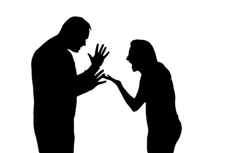 Silhouette of quarrelling man and woman, isolated on a white background. Married couple husband and wife, violence in the evening light of home living roomの写真素材