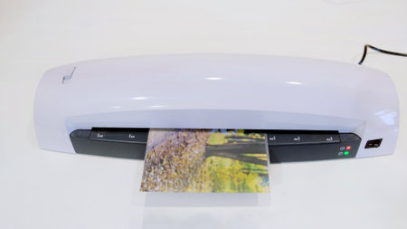 A machine for laminating photos and documents with plastic. Desktop white laminator, close-upの写真素材