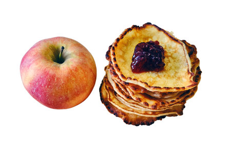 A red apple lies next to the pancakes, isolated on a white backgroundの写真素材