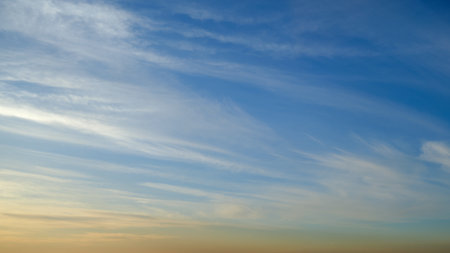 Cirrus clouds float in the blue evening skyの写真素材