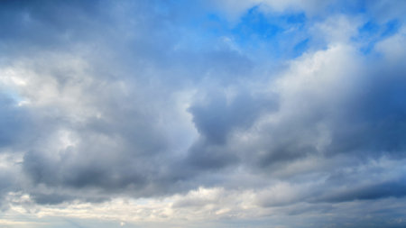 Dramatic sky with dark cumulus clouds. Menacing heavy clouds in the blue skyの写真素材