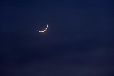 New moon in the initial phase on a dark night skyの写真素材