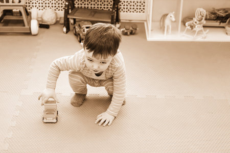 Toddler baby is playing with toys in kindergarten. Happy child boy in the playroom. Kid aged one year nine monthsの写真素材