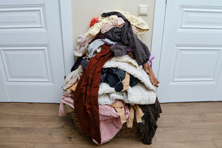 Sorting clothes after washing. Filling the basket with adult and baby clothingの写真素材