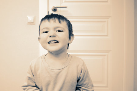 Little baby whimpers and is naughty. Small child is crying and suffering in the home living room. Kid aged one year nine monthsの写真素材