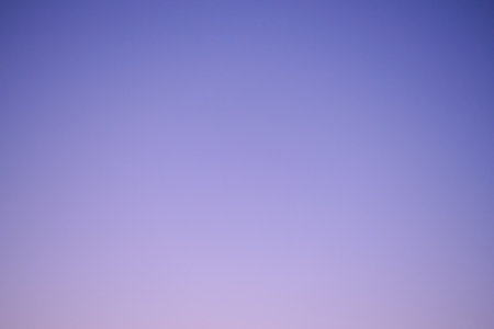 Sunset sky gradient from blue to purple, copy space. Clear sunset sky with the bright light of the setting sunの写真素材