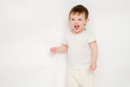 A happy baby on a studio white background. Portrait of a smiling child. Kid aged about two years (one year nine months)の写真素材