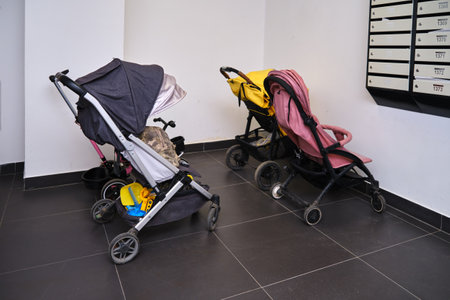Baby strollers are in the storage room. A pram in the entrance of an apartment building near the mailboxesの写真素材