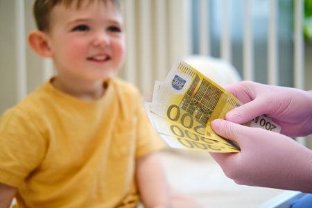 The doctor is going over the euros money she received from the baby mother for the pediatric check-up. Kid aged about two years (one year eleven months)の写真素材