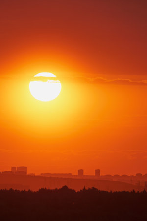 The hot sun beat down on us as we watched the sunset from the city, painting the sky with shades of red and gold.の写真素材