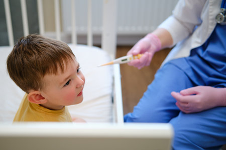 The doctor is checking the temperature of the baby with an electronic thermometer. Kid aged about two years (one year eleven months)の写真素材
