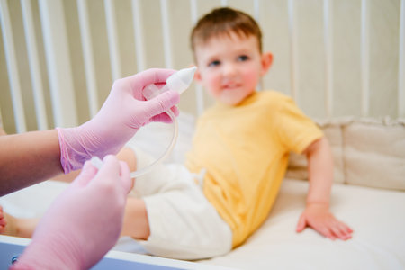 The child hygiene kit included a white nasal aspirator for baby, designed to be gentle on the delicate respiratory system. Kid aged about two years (one year eleven months)の写真素材