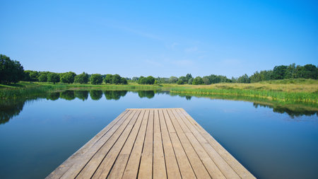 Wooden pier with blue surface of lake water, copy space for text