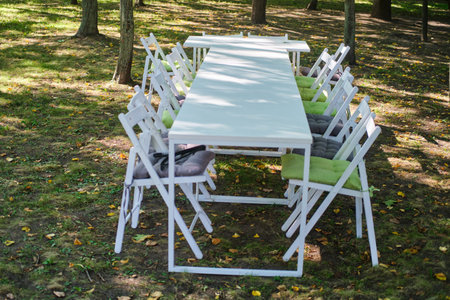 White wooden table and chairs in the park. Table with chairs and tableclothの写真素材