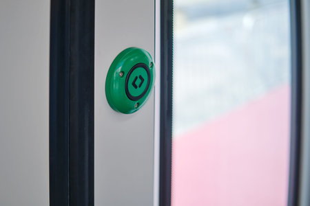 Green emergency button on the door of a train, close-up