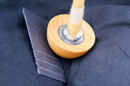 The woman carefully spins the wool into thread using a drop spindle, showcasing her skill in the craft of spinning.の写真素材