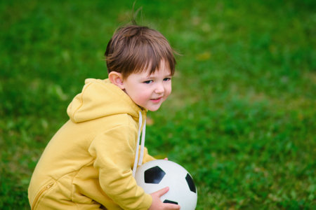 The child is playing with a soccer ball while walking in the park. Kid aged two years (two-year-old boy)の写真素材