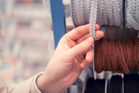 Closeup of a woman's hand choosing knitted clothes in the store