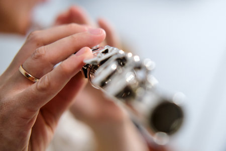 The female flautist's hand is shown in close-up as she skillfully plays the flute during the classical music concert.の写真素材