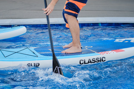 Swimming in the pool with a man on a paddle board.の写真素材