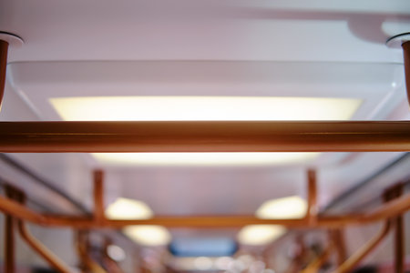 The interior of a modern train car with brown railings for support during the tripの写真素材