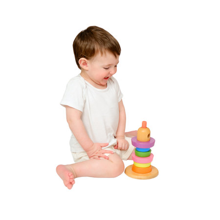 Happy baby play educational toys on studio, isolated on white background. Portrait of a smiling child playing while sitting on the floor. Kid about two years old (one year nine months)の写真素材