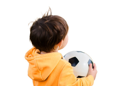 Baby boy is enjoying a game of soccer in the autumn field, isolated on white background. Kid aged two years (two-year-old boy)の写真素材