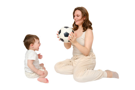 Happy baby with mother play with fotball ball on studio, isolated on white background. Portrait of a smiling child with mom and playing while sitting on the floorの写真素材